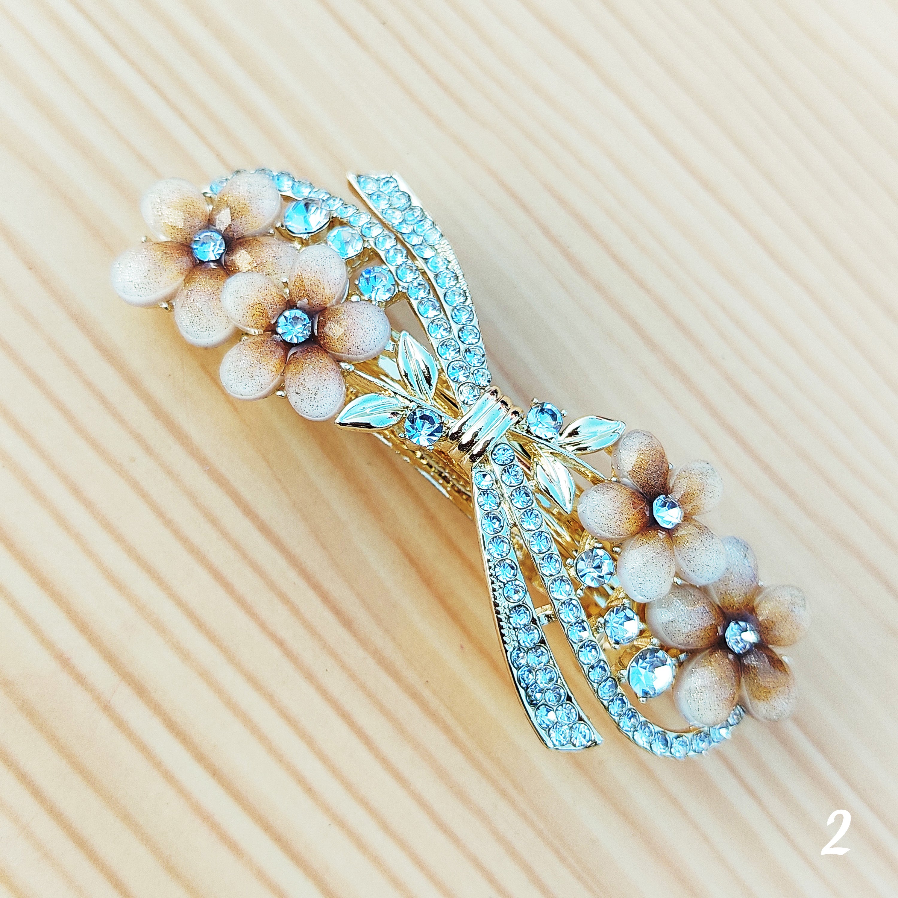 Elegant floral bow hair clips featuring sparkling crystal stones and a glossy enamel finish