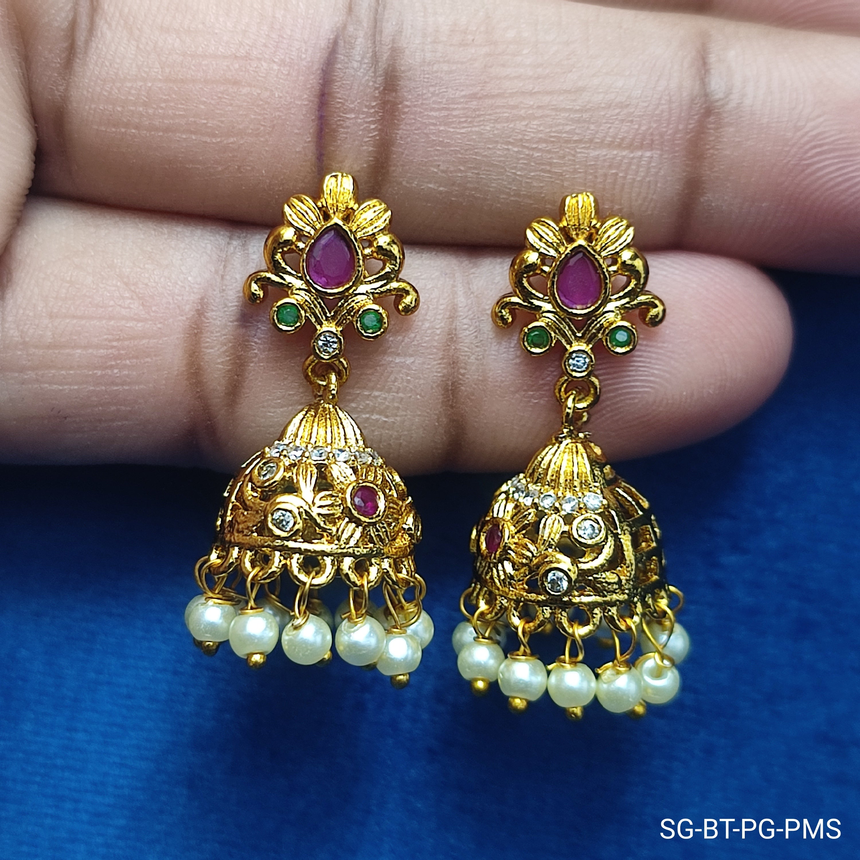 Radiant gold-toned jhumkas with pearl drops