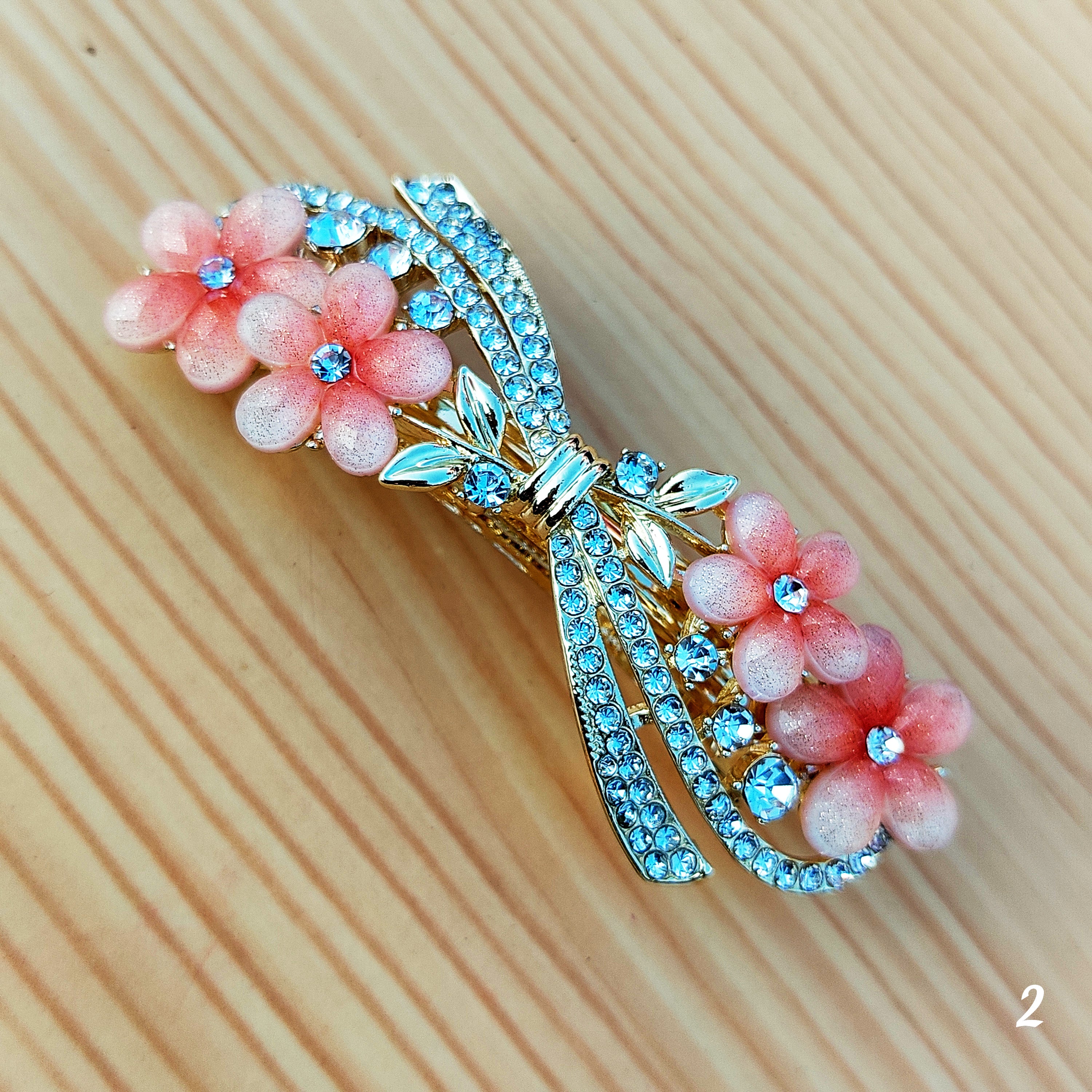 Elegant floral bow hair clips featuring sparkling crystal stones and a glossy enamel finish